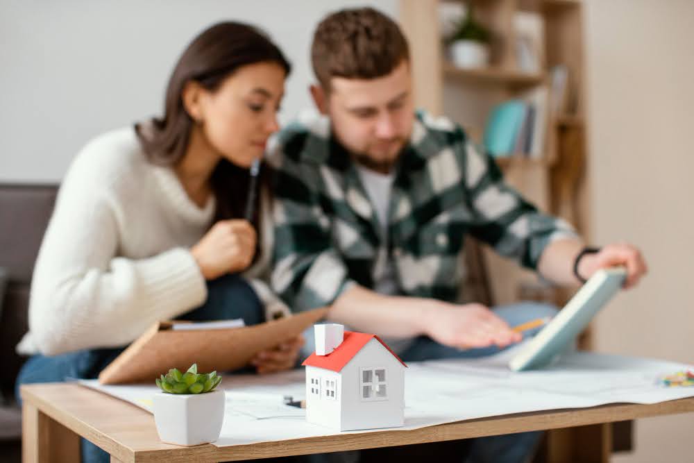 A Couple sitting at a table reviewing offers to buy a home in Utah.